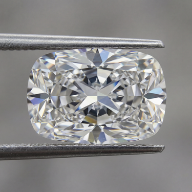Cushion-shaped diamond held between tweezers against a blurred background